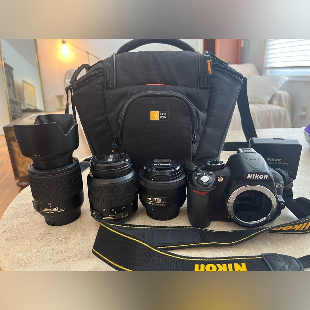 Nikon D3100 DSLR Camera with 35mm, 18-55, 55-200 lenses, charger, strap and bag.